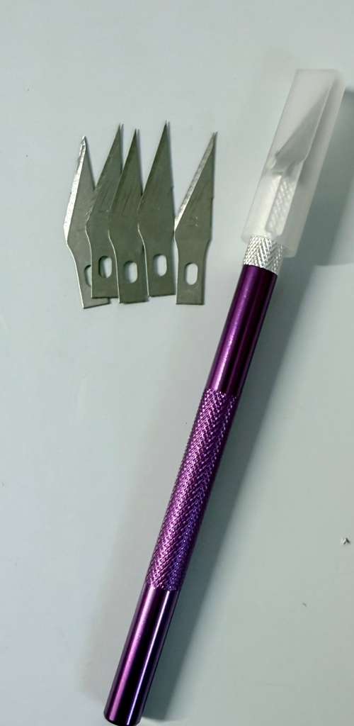 Cutter morado 5 cuchillas extras.